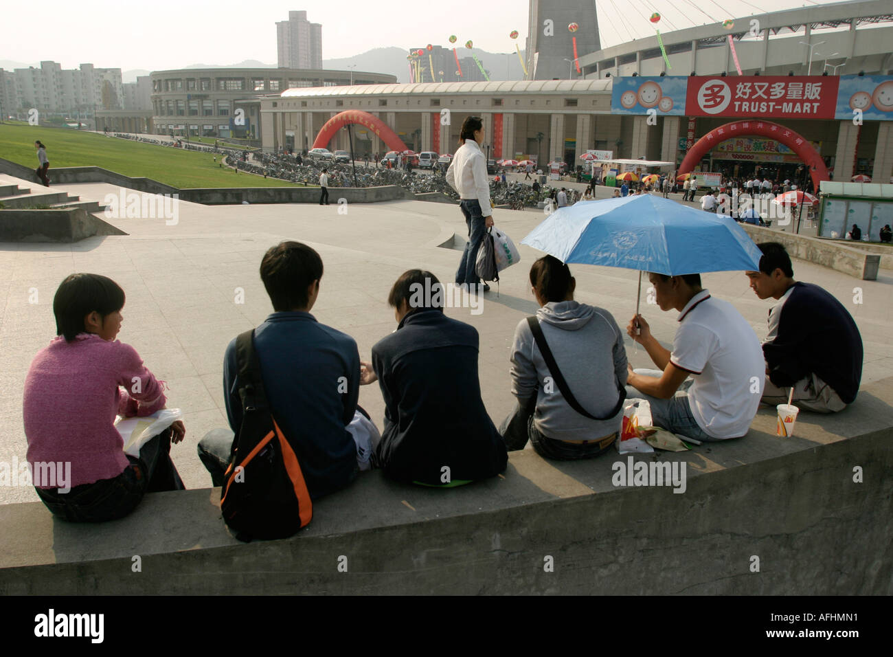 Studenten sitzen auf einer Mauer Stockfoto