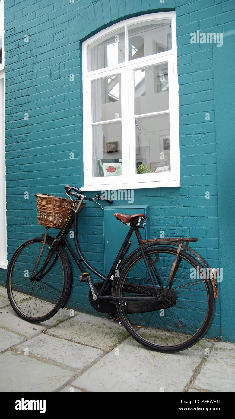 Ein altes Fahrrad blau bemalte Wand gelehnt Stockfoto