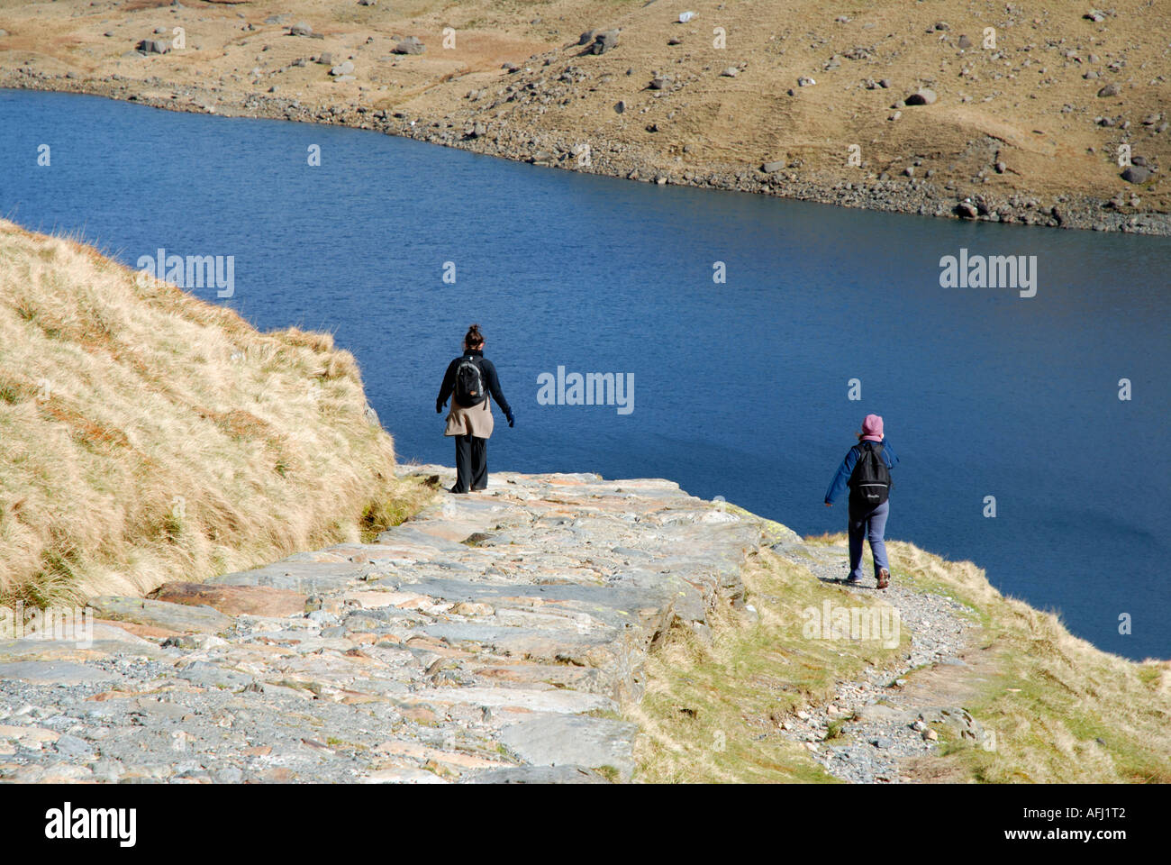 Zwei Wanderer über Llyn Llydaw Llwybr y Mwynwyr Bergarbeiter Track Snowdonia Nationalpark Mount Snowdon Yr Wyddfa Wales Großbritannien Großbritannien Stockfoto