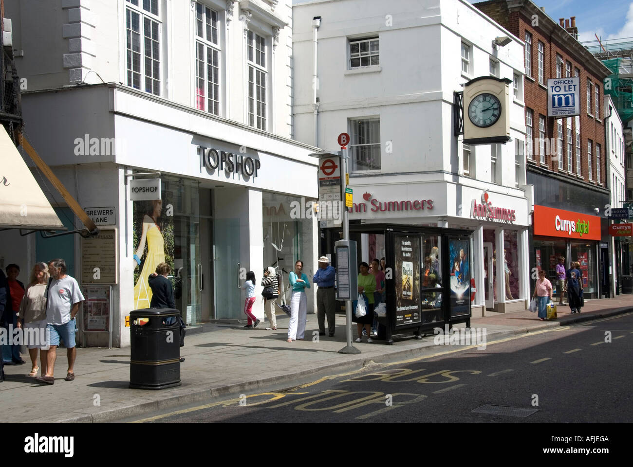 Richmond upon Thames Straßenszene in einem Teil des Einkaufsviertels Darunter Topshop Ann Summers und Currys Digital mit Menschen warten An der Bushaltestelle London UK Stockfoto