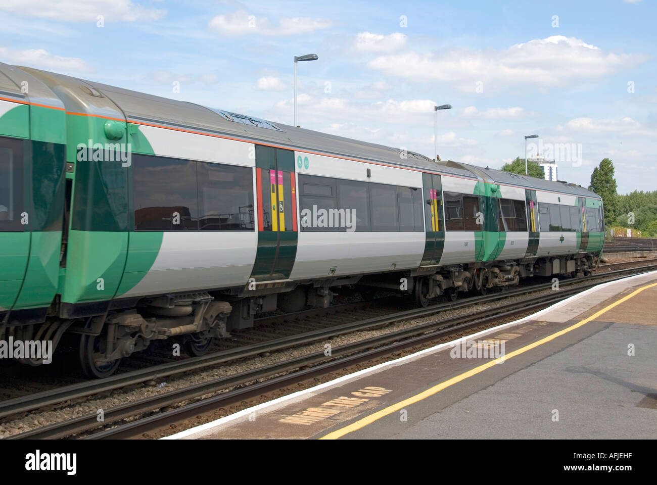 Clapham Junction Railway station mit dem Zug und dagegen die Lücke Sicherheit Slogans auf Bahnsteigkante Stockfoto