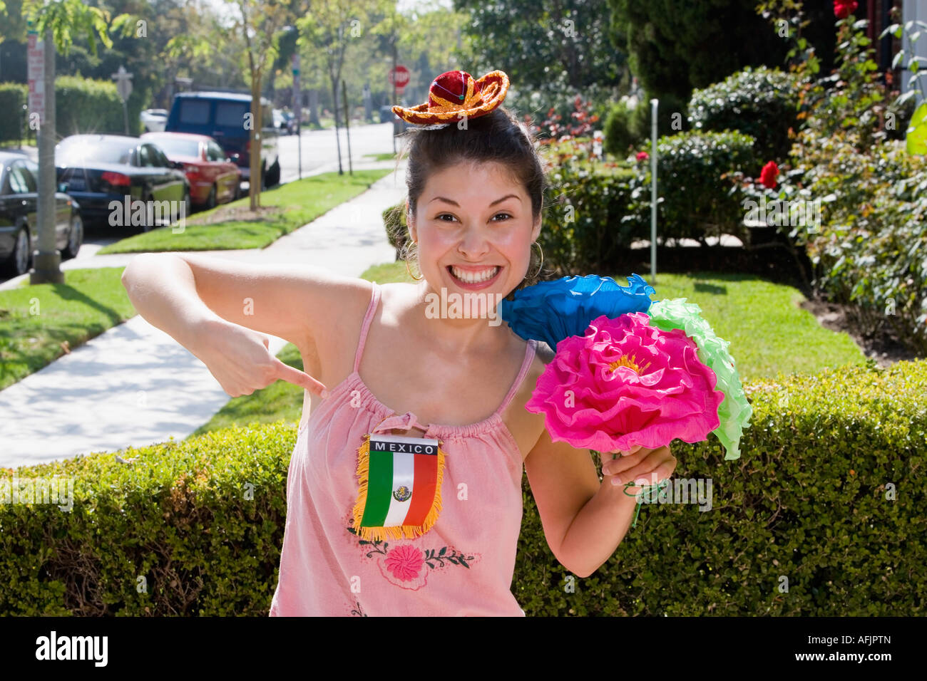 Frau hält Blumen und deutete auf mexikanische Flagge Stockfoto