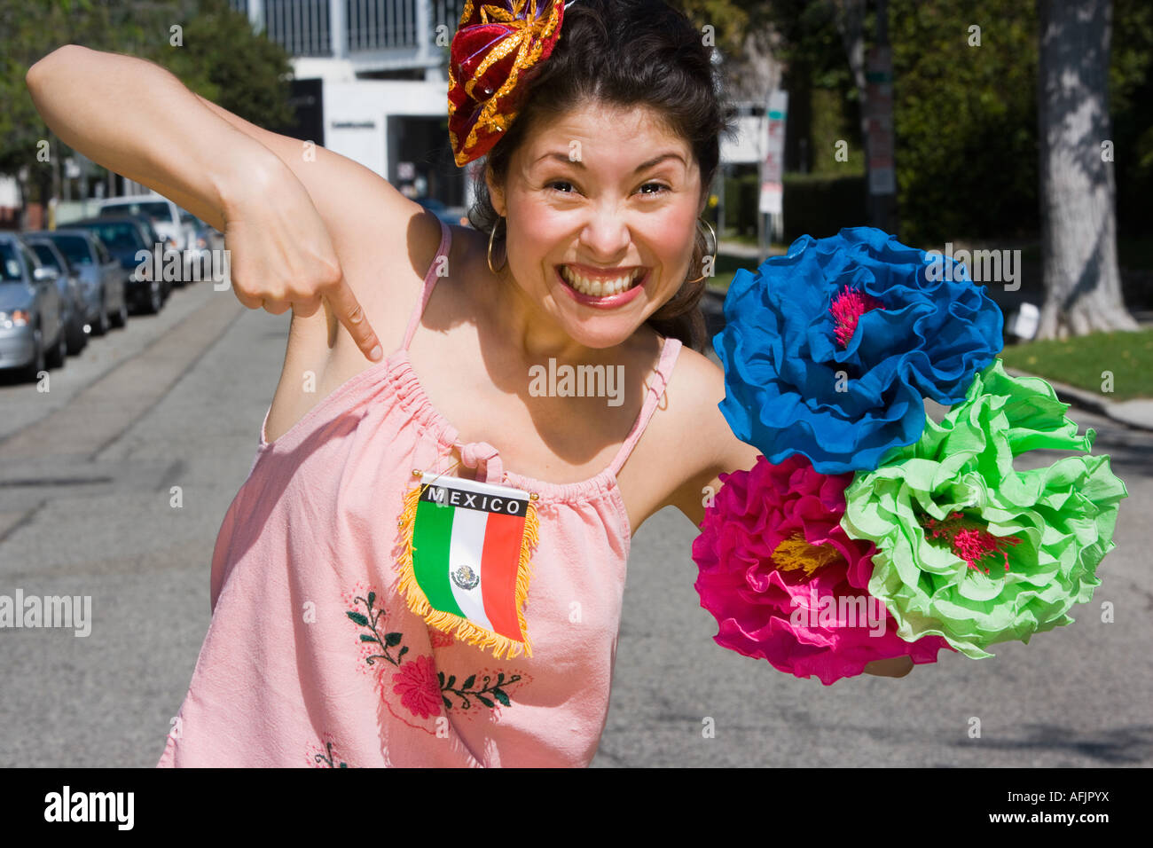 Frau hält Blumen und deutete auf mexikanische Flagge Stockfoto