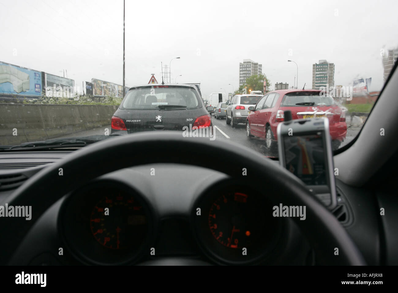 Armaturenbrett und Lenkrad Auto Stau mit PDA sat Nav an regnerischen Tag auf westlink Stockfoto
