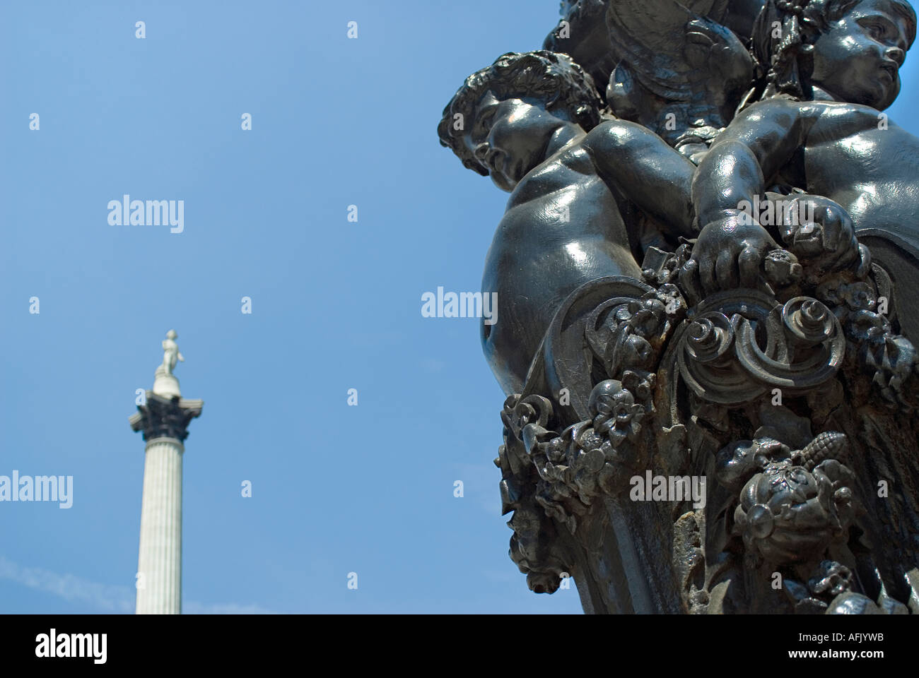 Verzierten gusseisernen Laternenpfähle am Trafalgar Square mit Nelsons Säule im Hintergrund Stockfoto