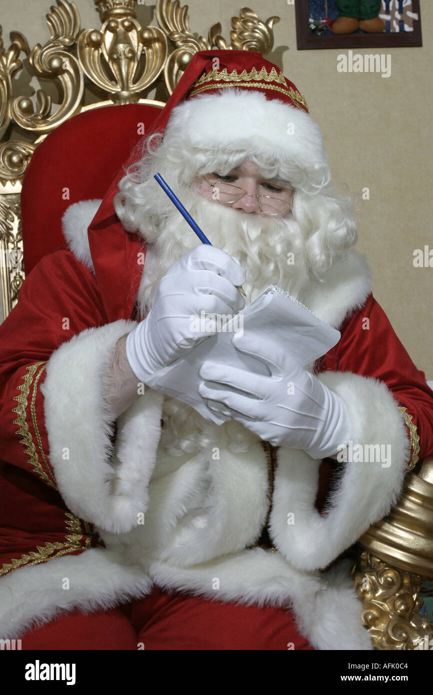Santa Claus, eine Liste auf seinem Thron Stockfoto