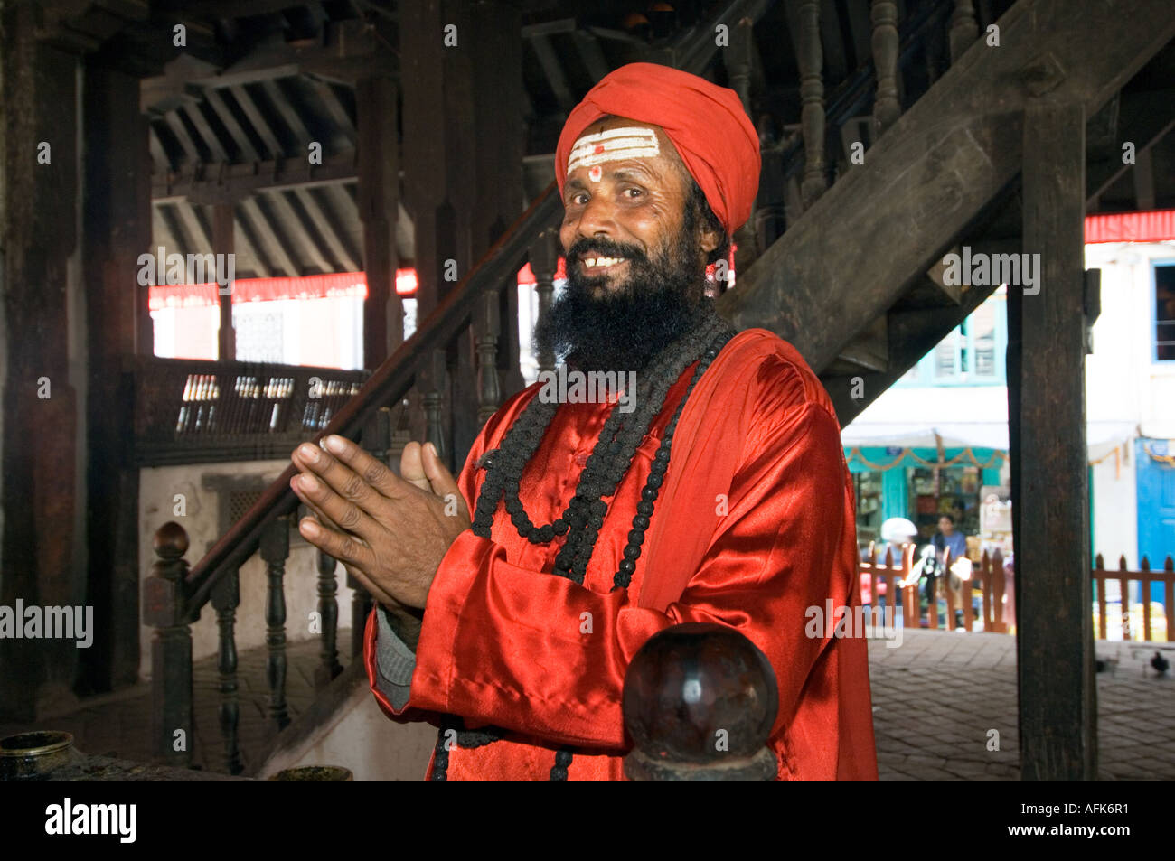 rot gekleideten Siddhu Sadhu heiliger Mann Patan Durbar Square Tempel Gebäude Kathmandu NEPAL Asien Katmandu ethnischen Saddhu Lächeln Stockfoto