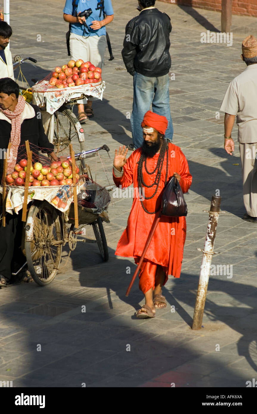 rot gekleideten Siddhu Sadhu heiliger Mann geht einkaufen Patan Durbar Square Tempel Gebäude Kathmandu NEPAL Sadu Asia Kathmandu ethn Stockfoto