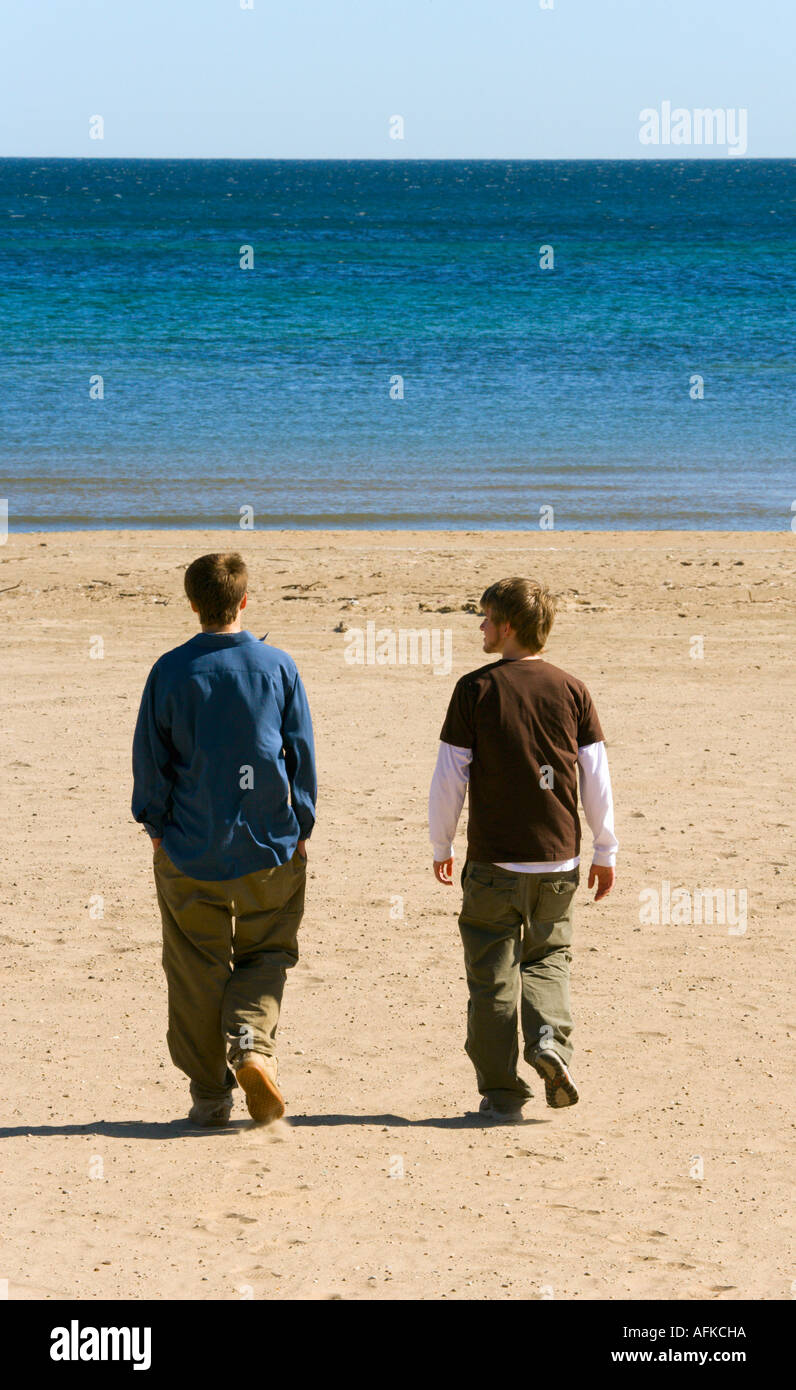 Jungs im Teenageralter zusammen spazieren am Strand mit Lake Michigan im Hintergrund. Stockfoto