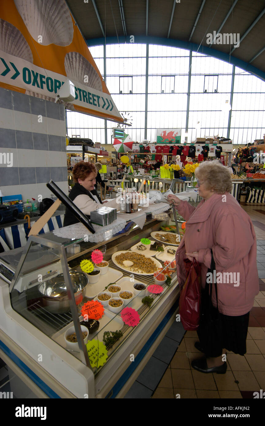 Herzmuscheln und Laverbread (Laver Brot) zum Verkauf an Swansea indoor-Markt - Seniorin Meeresfrüchte kaufen. Wales UK Stockfoto