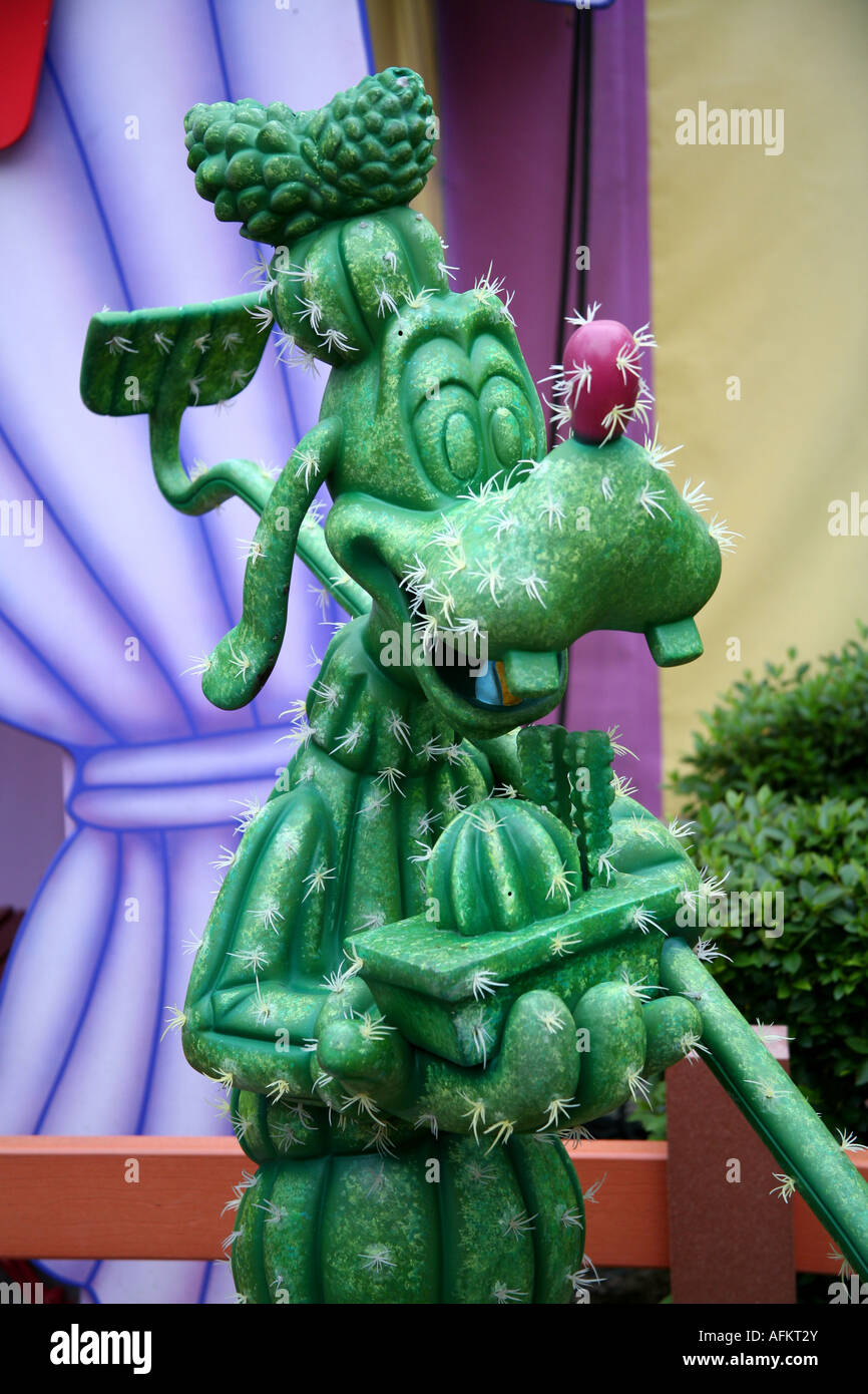 Disney-Figuren auf einer Magic Kingdom Goofy Statue gemacht eine künstliche Kakteen Stockfoto