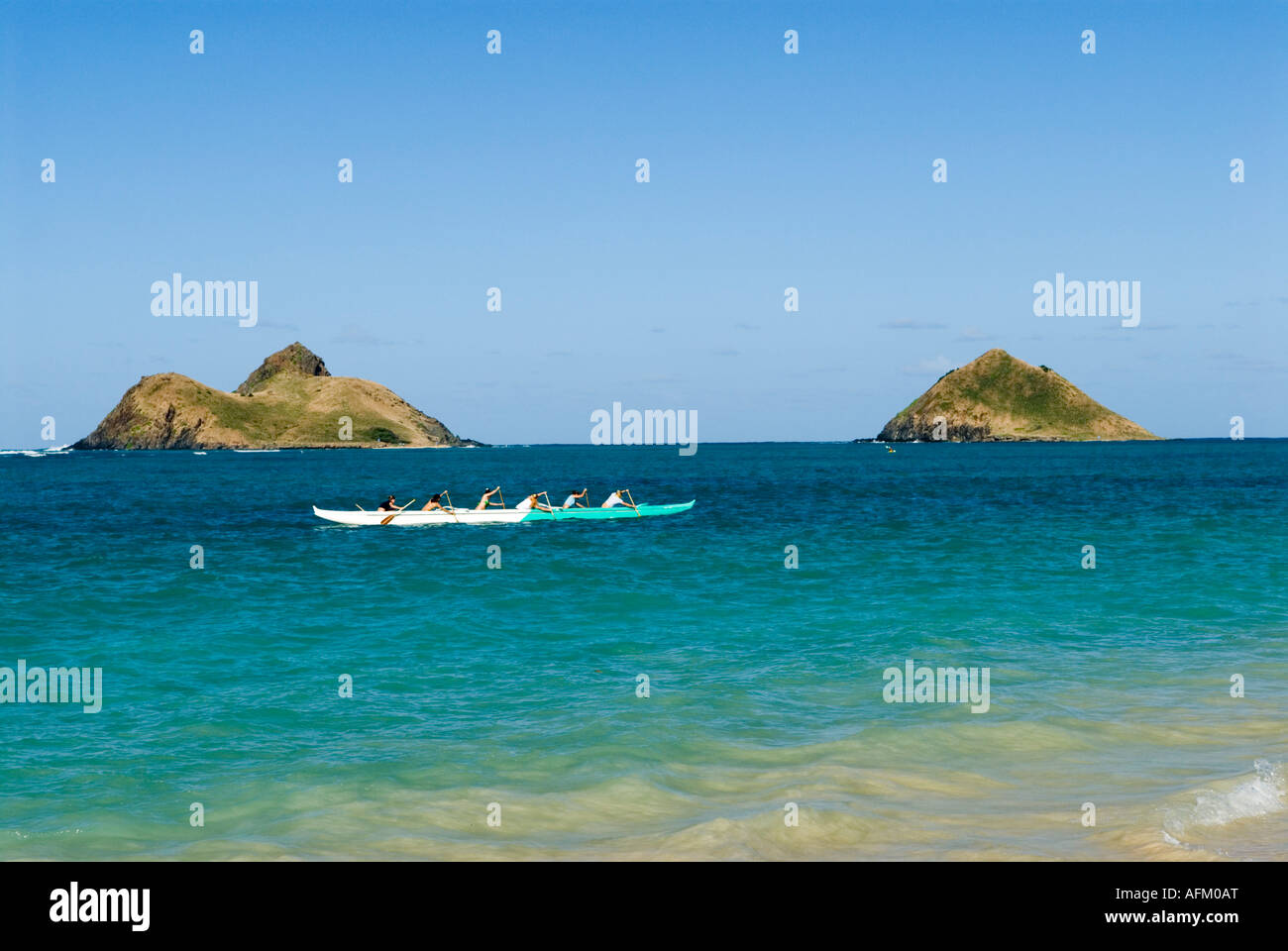 Ausleger Kanuten off Lanikai Beach Mokulua Inseln im Hintergrund Oahu Hawaii Stockfoto