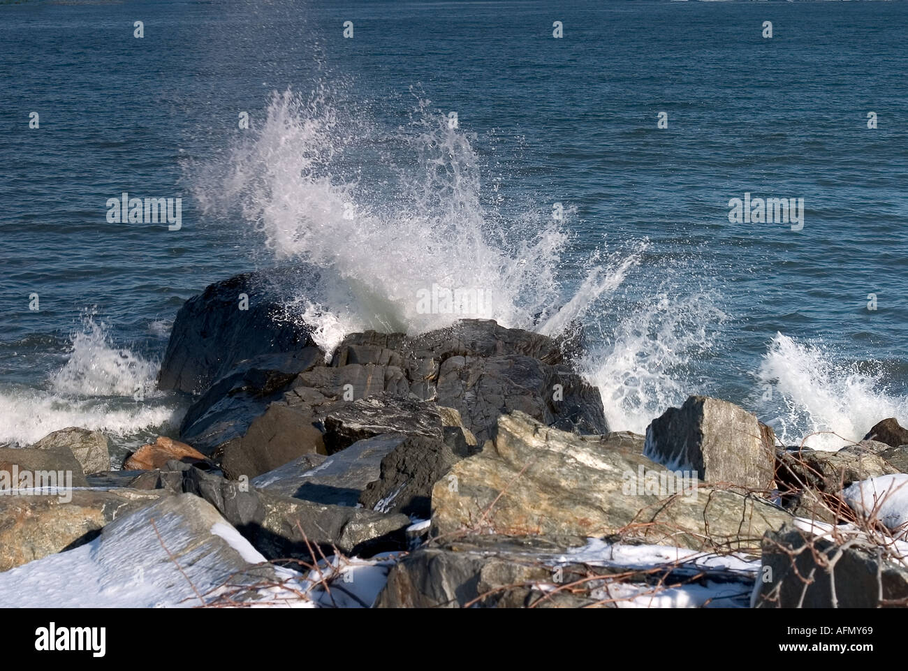 Wellen brechen an einem steinigen Strand Stockfoto