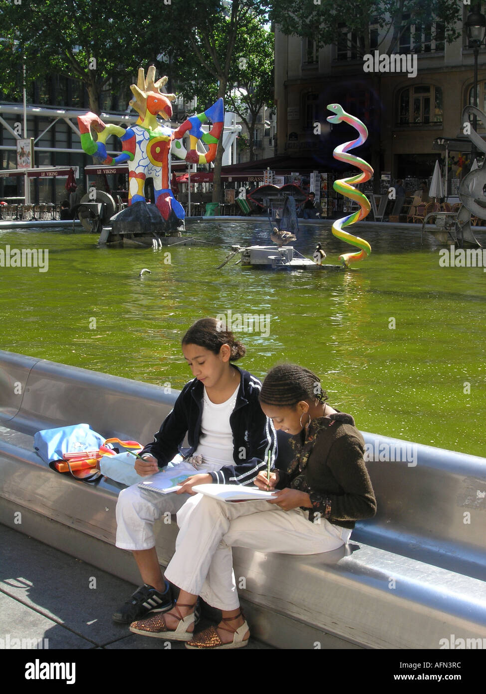 zwei SchülerInnen zeichnen an bunten Tinguely-Brunnen am Place Igor Strawinsky Paris France Stockfoto