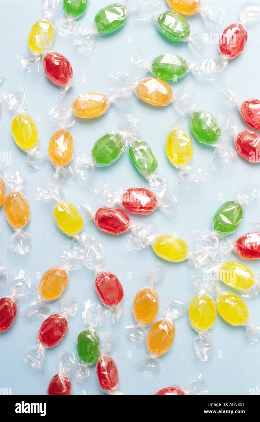 Viele Farben-Candy in durchsichtigen Kunststoff Wrapper verstreut auf blauem Hintergrund Stillleben Stockfoto