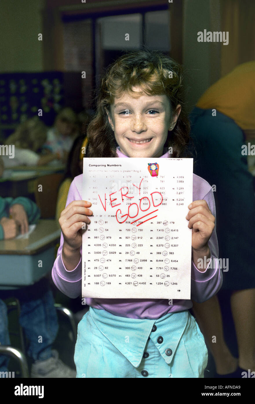 Lächelnd 3. Klasse Studentin zeigen zeigt ein Papier sagen sehr gut Stockfoto