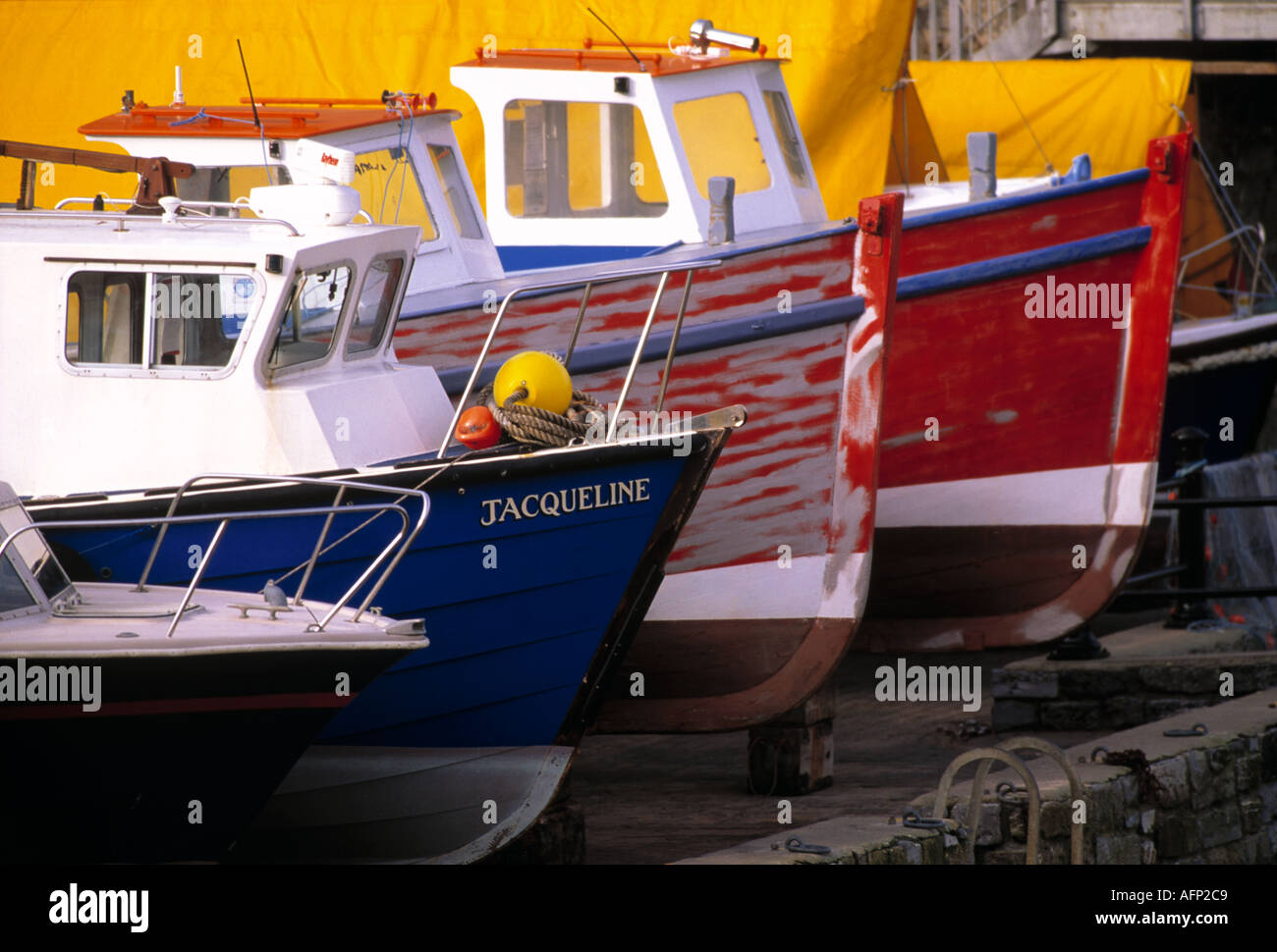 England Tenby Wale bunte Fischerboote in Tenby Bootshafen gestapelt Stockfoto
