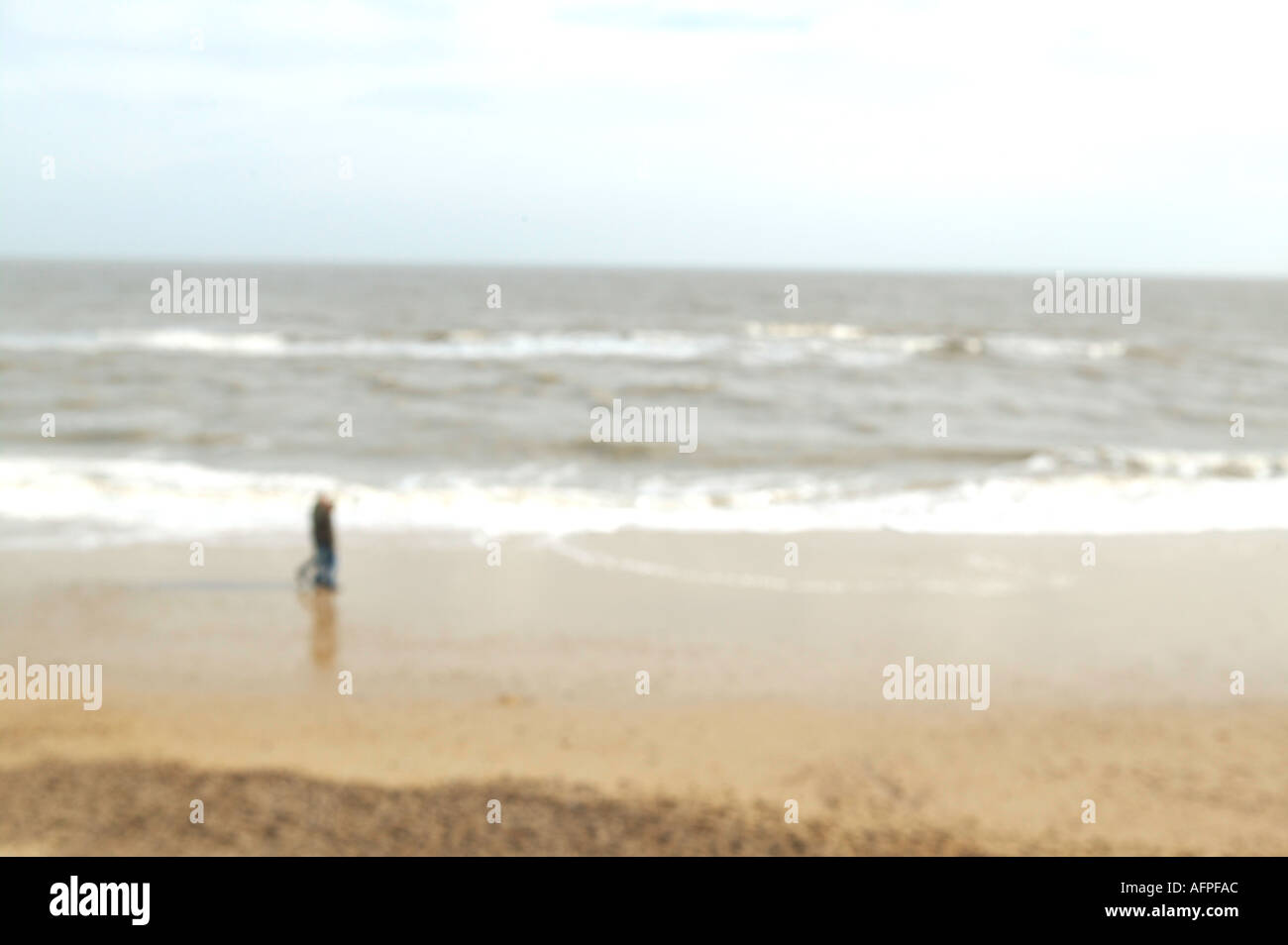 einsame entfernte Figur zu Fuß auf Küstenlandschaft Stockfoto