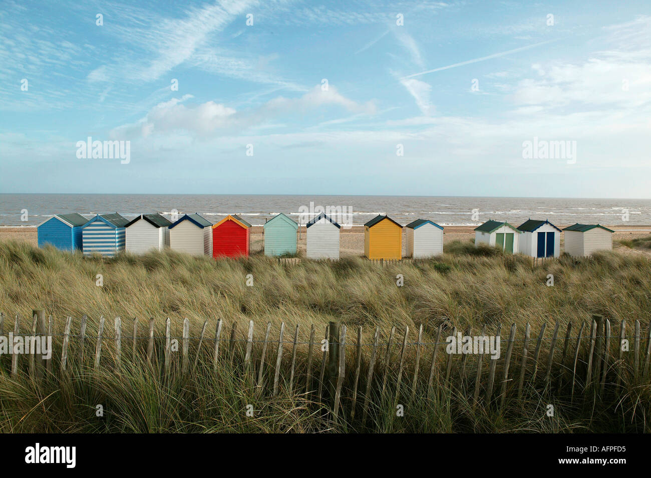 Linie der Strandhütten auf einem windgepeitschten englische Southwold Küste beliebt bei wohlhabenden Touristen einschließlich der helle Farben Stockfoto