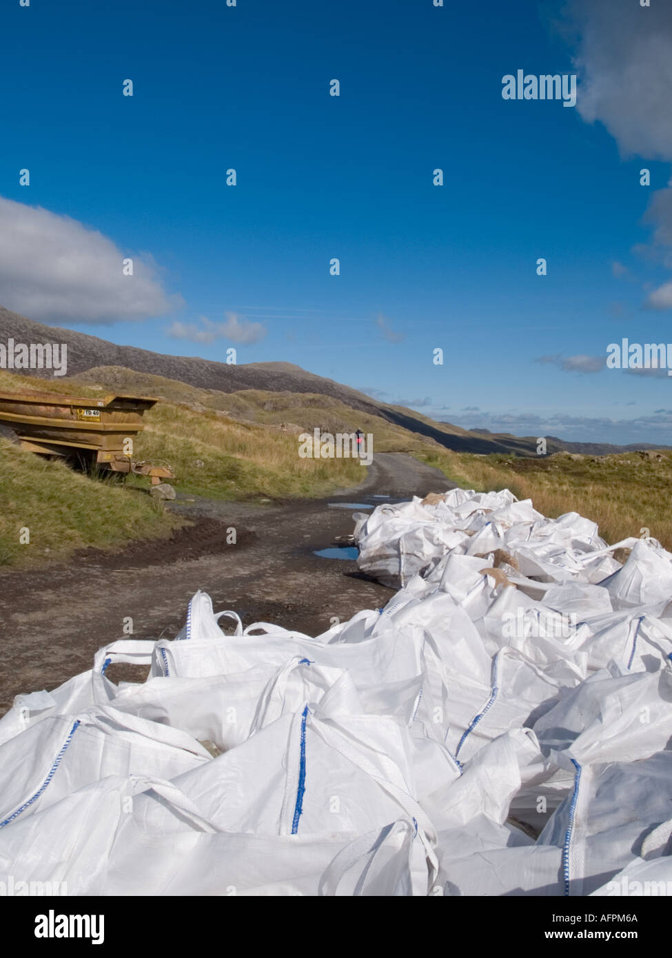 Taschen von Steinen für Fußweg reparieren beschädigte und abgenutzte Fußweg auf Bergarbeiter Track Pen y Pass Gwynedd North Wales UK Stockfoto