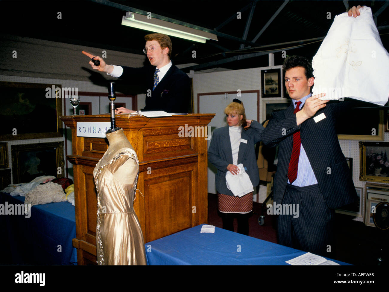 Auktionsräume Auktionator nimmt Gebote an Bonhams Lots Road. Assistent, der Gebrauchtwaren hält. London 1990s UK HOMER SYKES Stockfoto