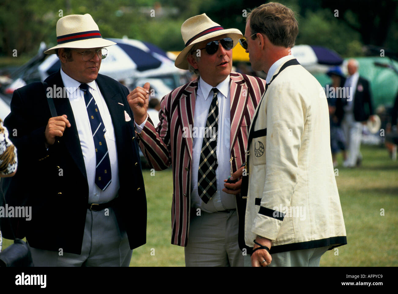 Männer mittleren Alters aus den 1980er Jahren sprechen, Freunde tragen Strohhüte und blaue Blazer in der Henley Royal Regatta. Henley on Thames Oxfordshire 1985 UK Stockfoto