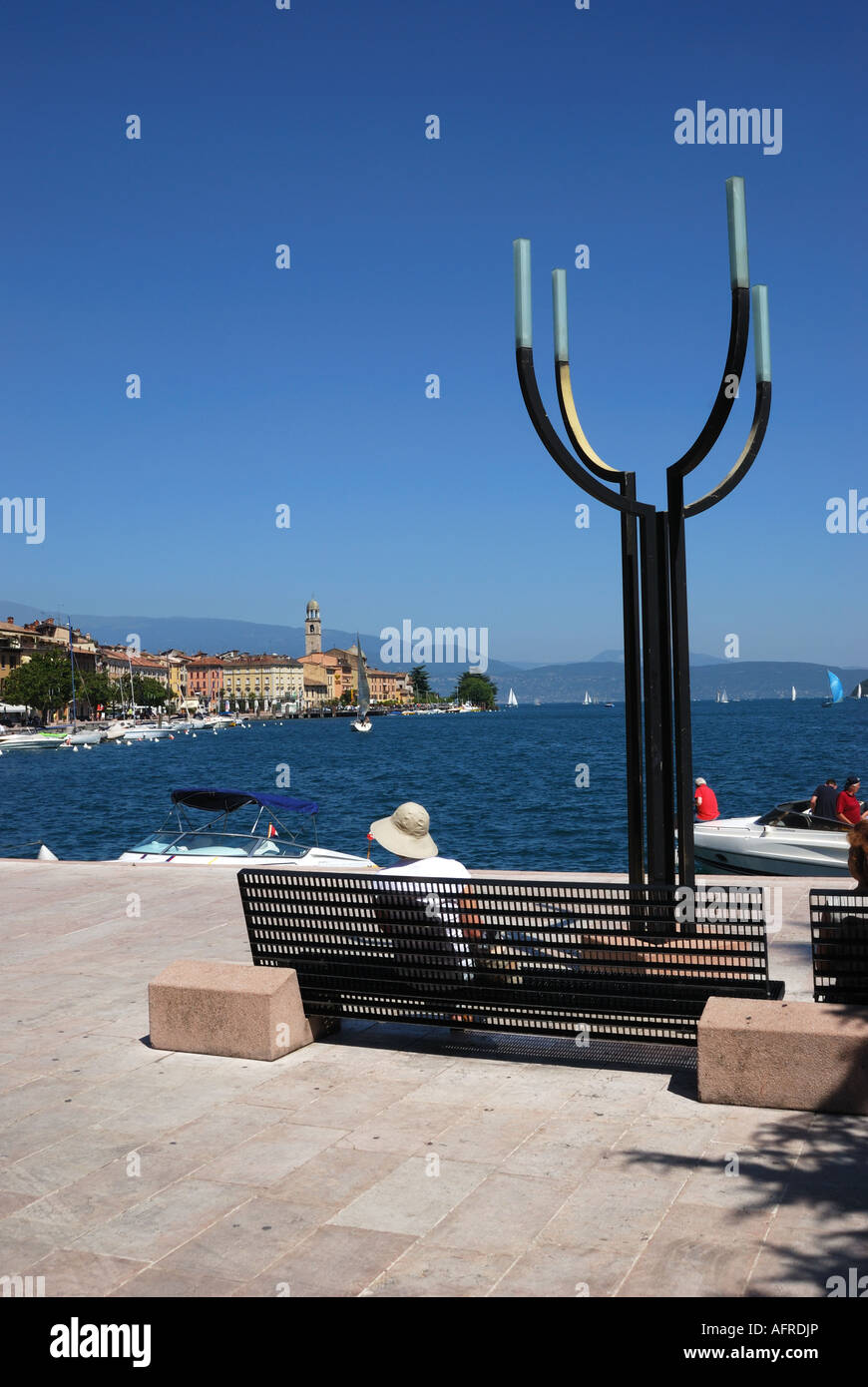 Frau sitzt am Seeufer in Salo, Gardasee, Italien Stockfoto