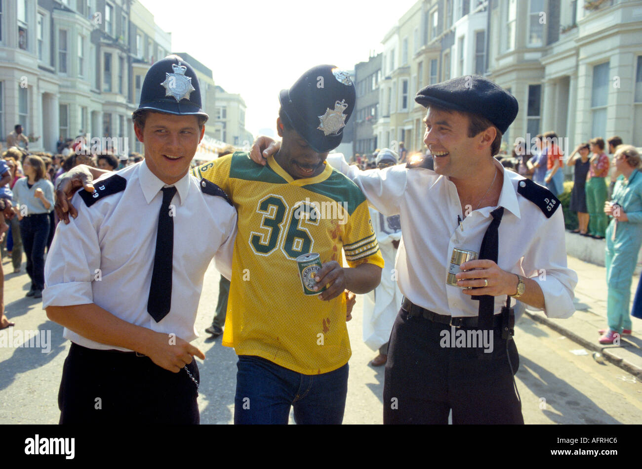 Freundliche Polizeipolizisten, die Spaß haben und sich im Geist des Notting Hill jährlichen Karnevals mit Bierdosen und einem ortsansässigen Mann der 90er Jahre, HOMER SYKES, ANSCHLIESSEN Stockfoto