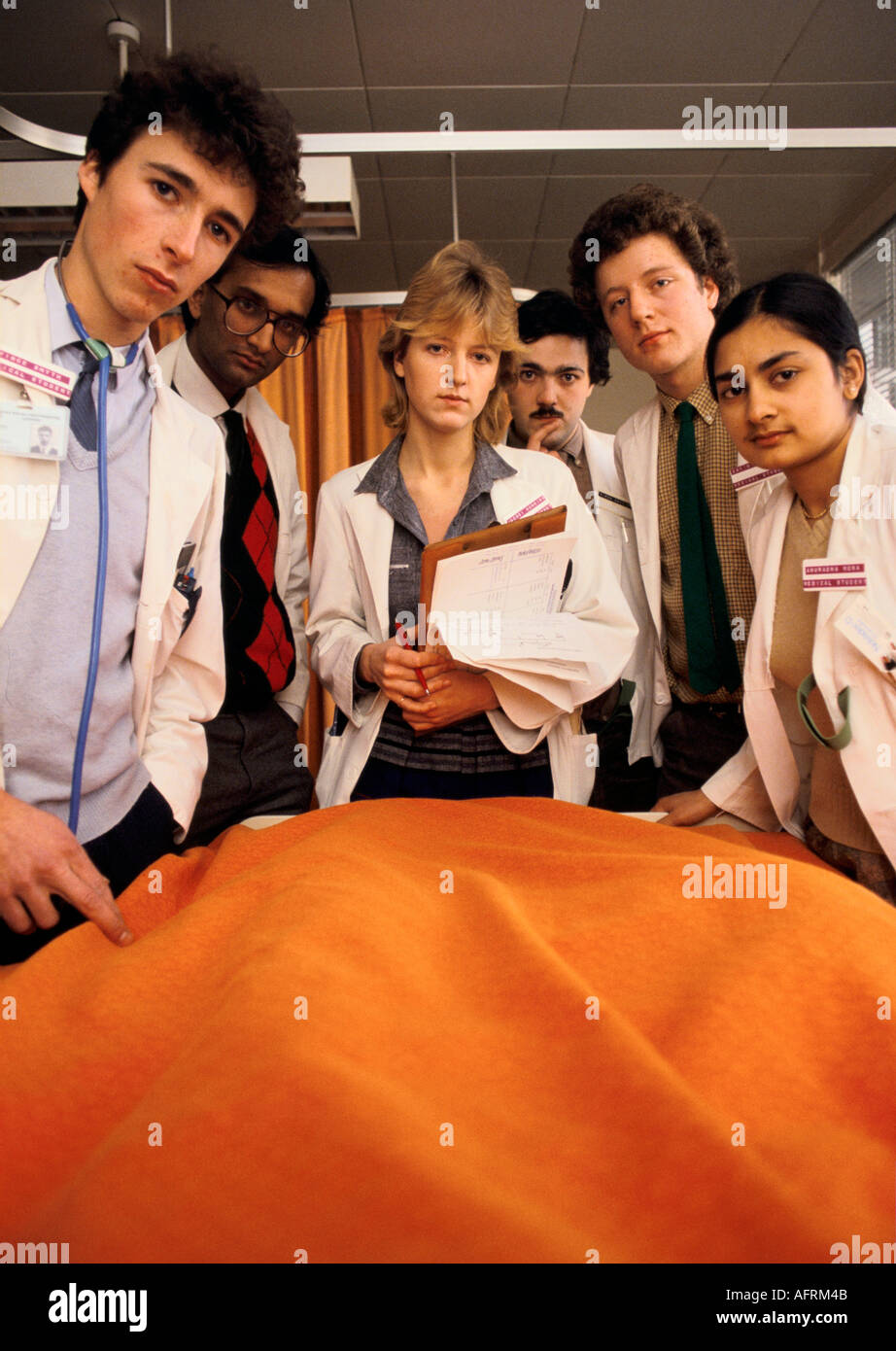 Juniorärzte, Medizinstudenten auf einer Ward Round. Lehrkrankenhaus St Georges Hospital South London 1980er Jahre Großbritannien. Auf einen Patienten HOMER SYKES herabschauend Stockfoto