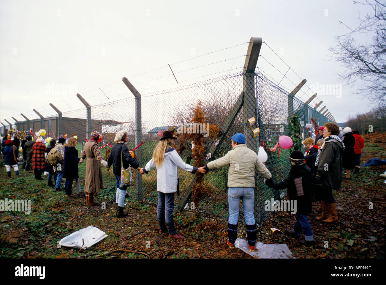 Begrüßen Sie das Base Greenham Common Frauen Friedenslager Mitglieder Frauen halten Händchen um den äußeren Umzaun der Militärbasis. 1983 1980er GB Stockfoto