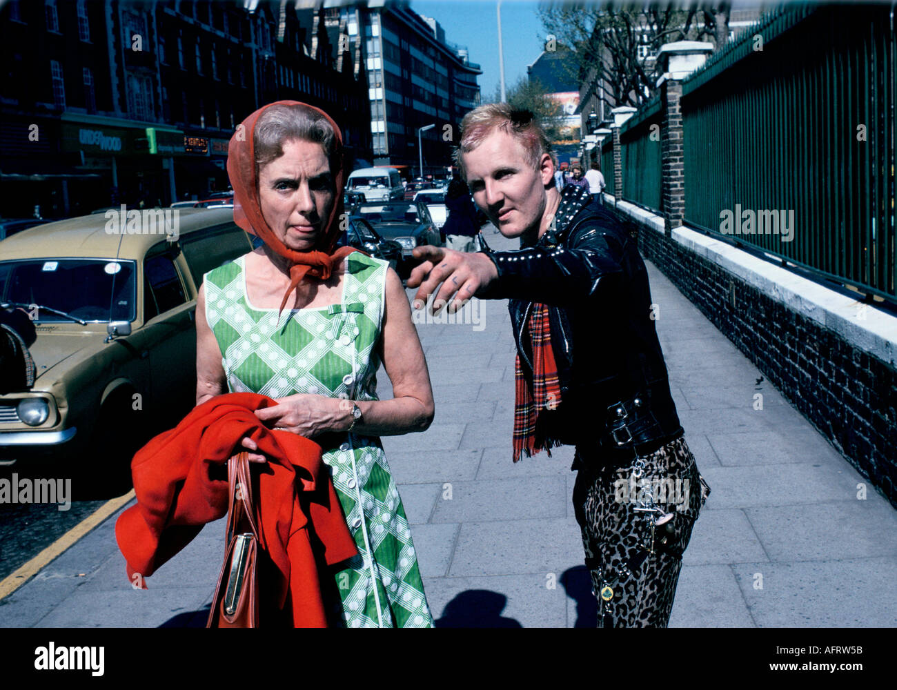 Punk hilft Passanten auf der Kings Road, Chelsea, London, die Frau, die die Zunge beim Fotografen 1970s UK 1979 HOMER SYKES ausstreckt Stockfoto
