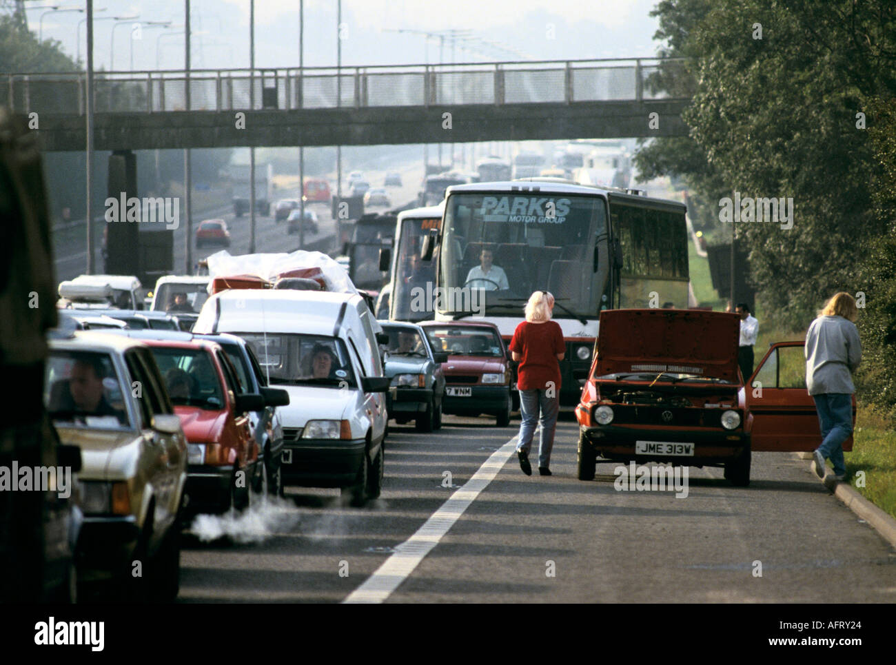 Autobahnverkehr Staus von Autos stecken in einem Stau auf der M1 zwei Personen mit Panne England 2020s 2021 UK HOMER SYKES Stockfoto