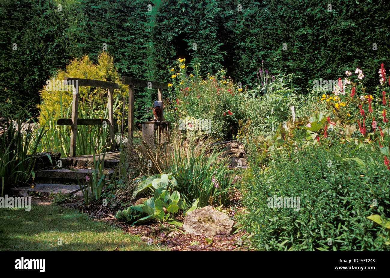 Bauerngarten mit Brücke Kreuzung Teich Wiltshire England Sommer 2004 Stockfoto