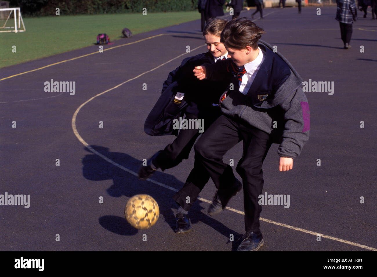 Gymnasium 1990er Großbritannien. Teenager spielen Fußball auf dem Schulhof, bevor sie nach Hause gehen Amersham Buckinghamshire 1990 HOMER SYKES Stockfoto
