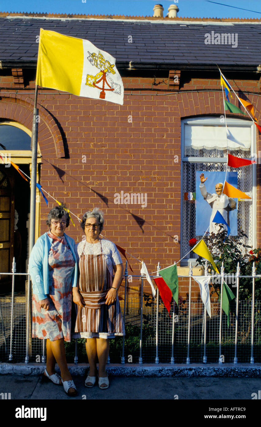 Papst Johannes Paul II. 1979 besucht Dublin, Irland. Frauen stehen vor ihrem Haus mit einem Poster des Papstes im Fenster Vatikanstadt-Flagge, die 1970er Jahre weht Stockfoto