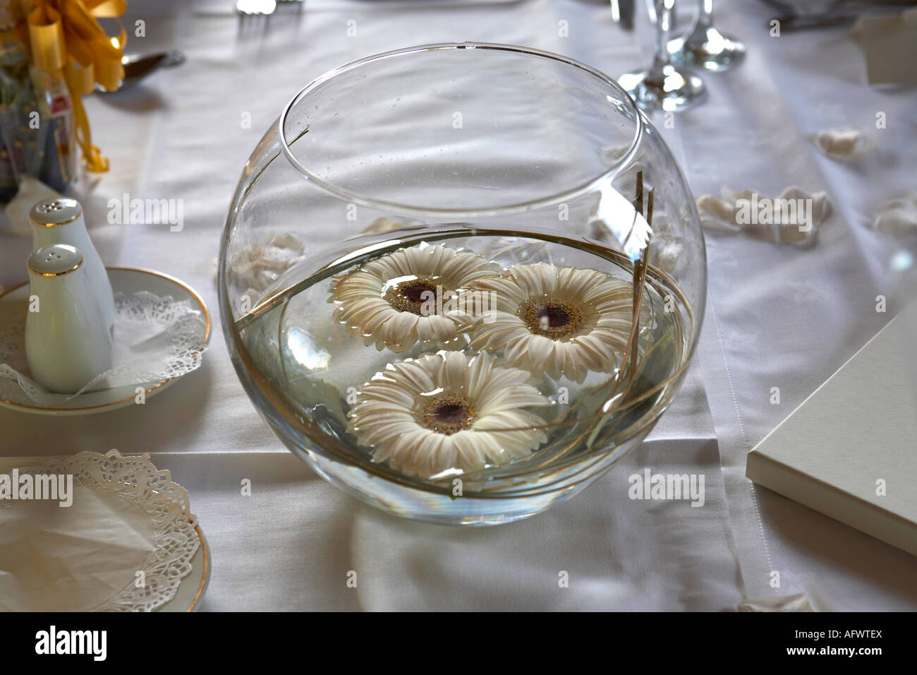 Schüssel mit Wasser mit schwimmenden Blumen als Tischdekoration bei