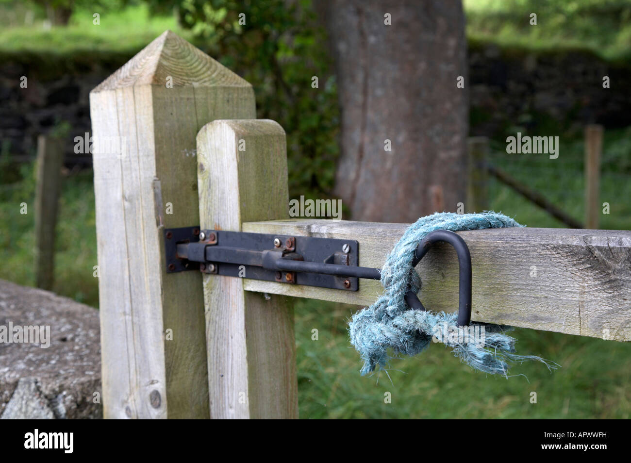blaues Seil gebunden hält Metalltor Befestigung am Holztor Eingang zum Ackerland finden County antrim Stockfoto