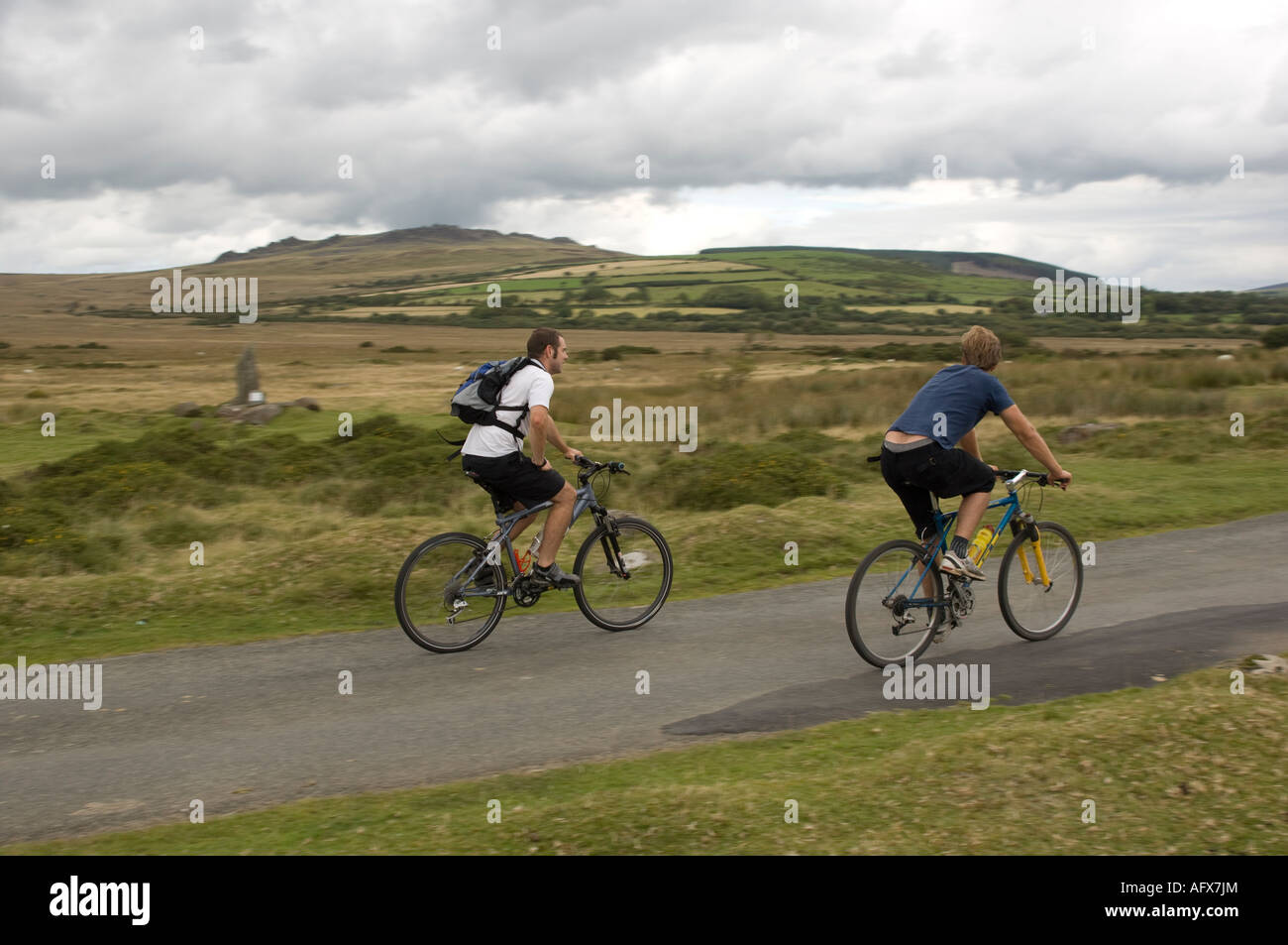 zwei Männer Radfahren Pembrokeshire Wales mit Carnmenyn, grau Preseli Hügel im Hintergrund, Nationalpark abgelegenen ländlichen Landschaft Tag Stockfoto