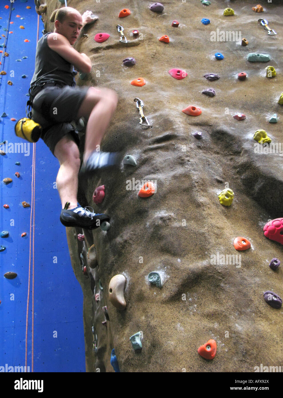 Ein einzelnes weißes Männchen auf einem indoor Wand Klettersteig Klettern. Stockfoto