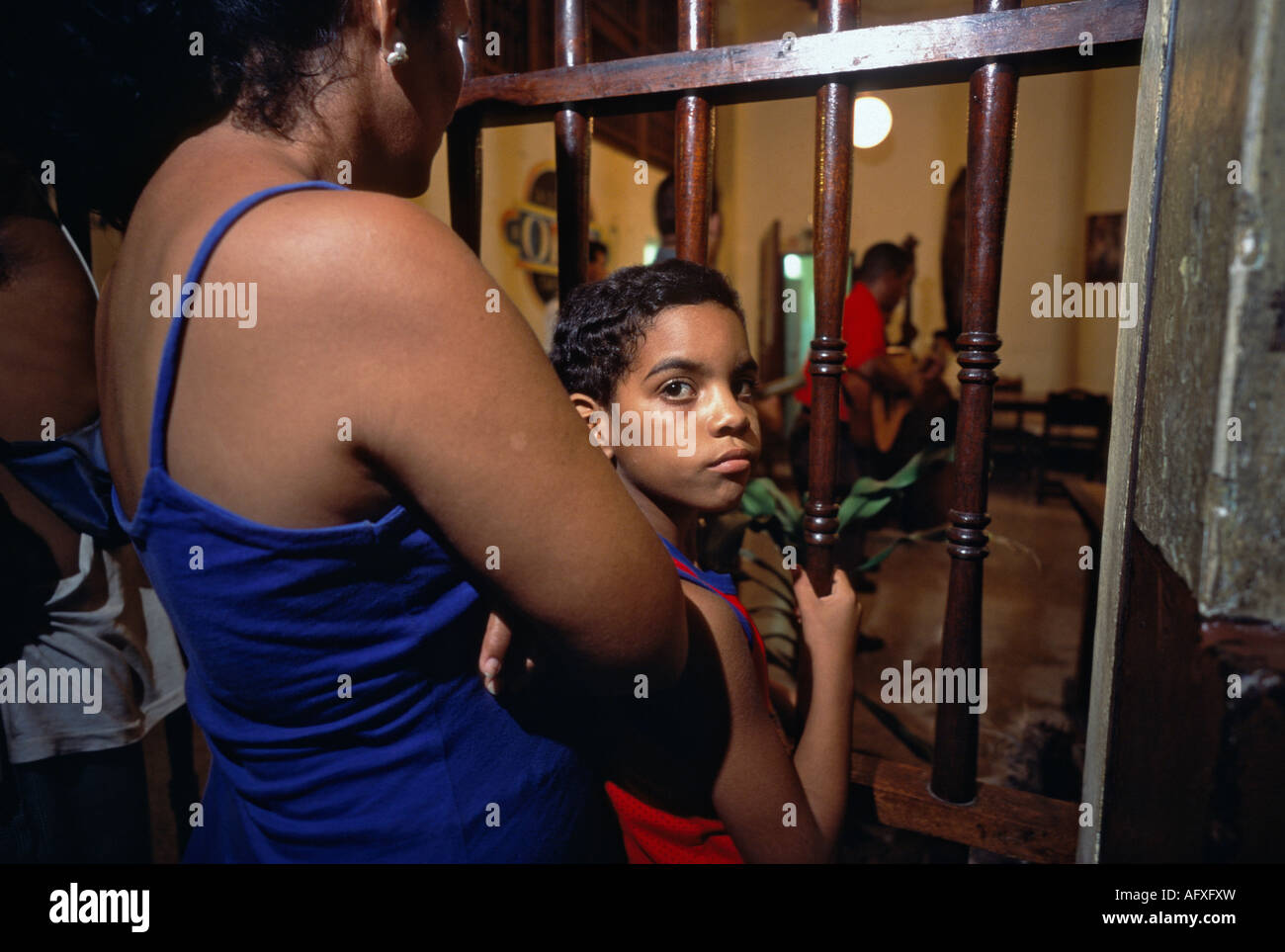 Junge hört Musik mit seiner Mutter aus vor einer Bar in einer Straße in Habana Vieja Havanna Kuba Stockfoto
