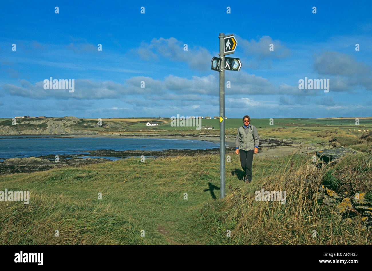ABERFFRAW ANGLESEY NORTH WALES UK September Frau zu Fuß entlang der Isle of Anglesey Küste in Porth Cwyfan Stockfoto
