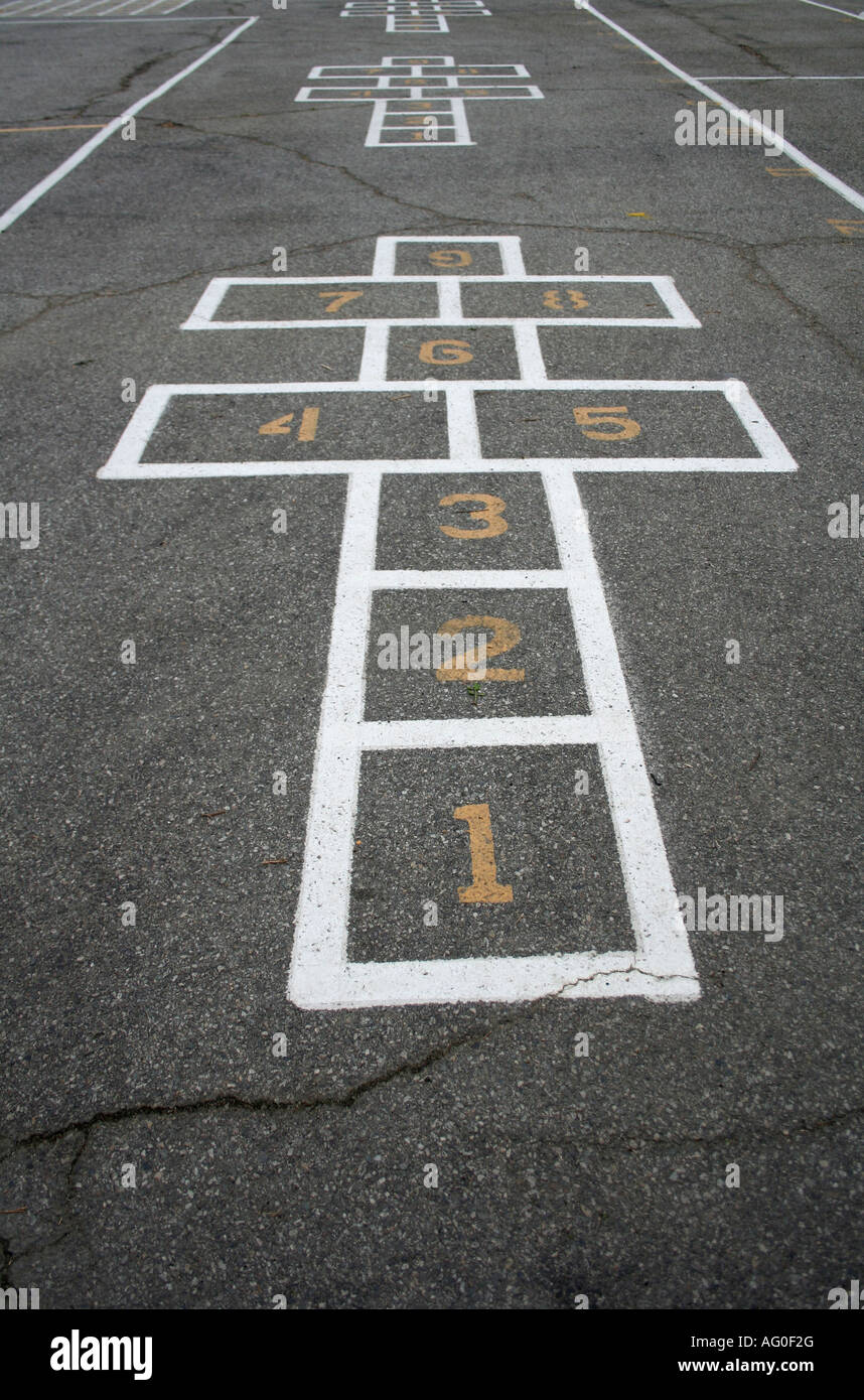 Hop Scotch Spiel auf schwarzem Asphalt mit gelb lackierten Zahlen weiß lackiert Stockfoto