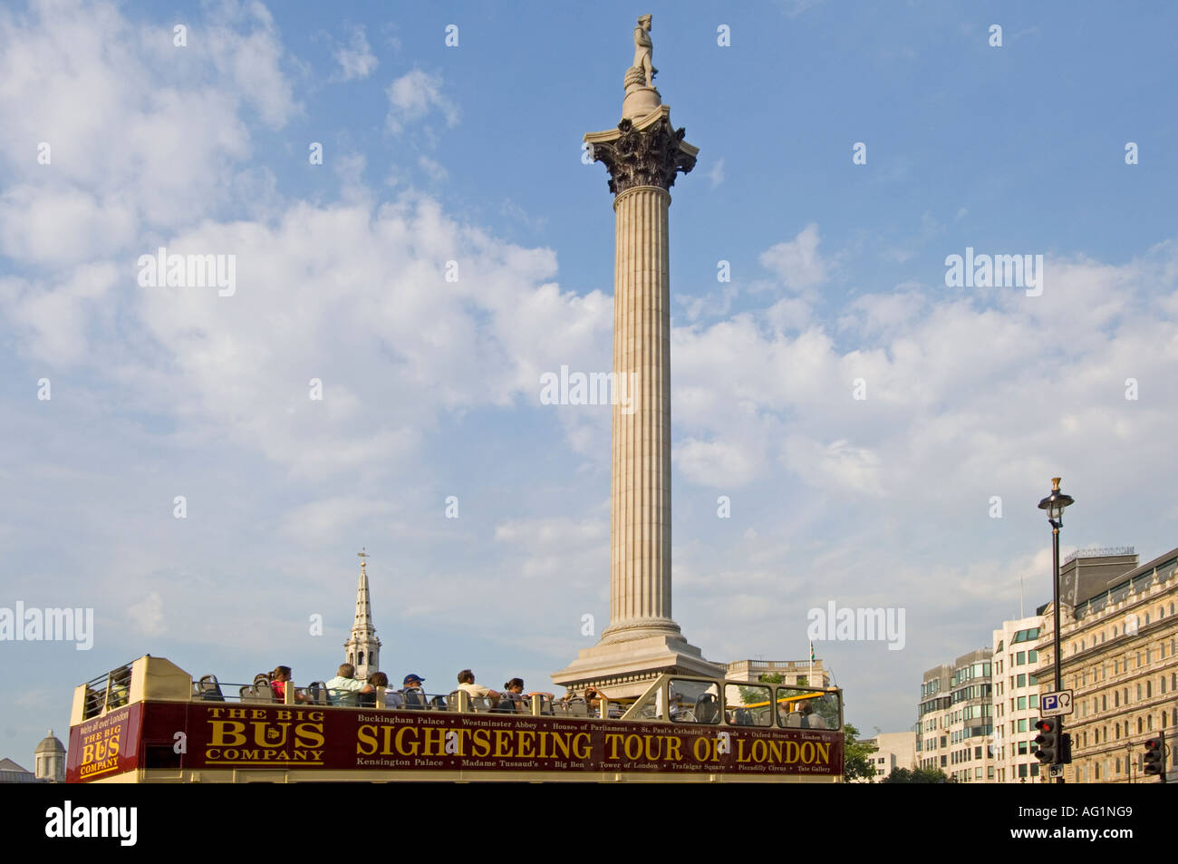 Oberdeck eines London Sightseeing Bus voller Touristen an einem Sommertag auf dem Trafalgar Square mit Nelsons Säule hinter. Stockfoto