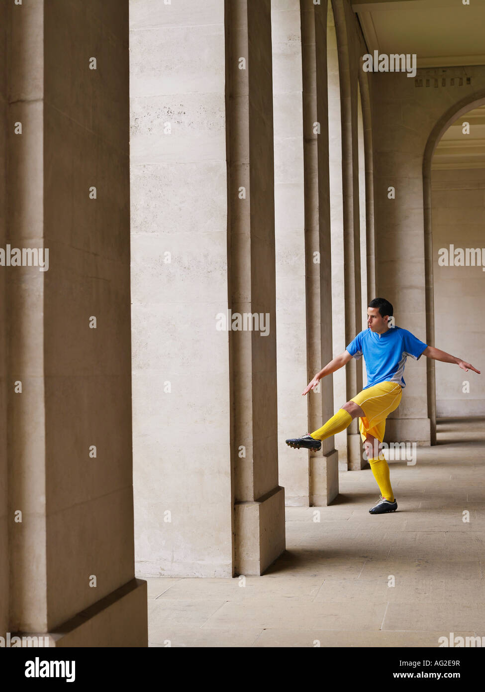 Fußball-Spieler treten Ball im Portikus Stockfoto
