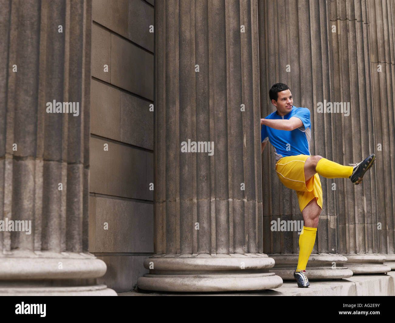Fußball-Spieler treten Ball stehend zwischen Spalten Stockfoto