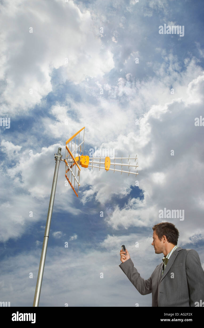Business Mann zeigt Handy an Antenne Stockfoto