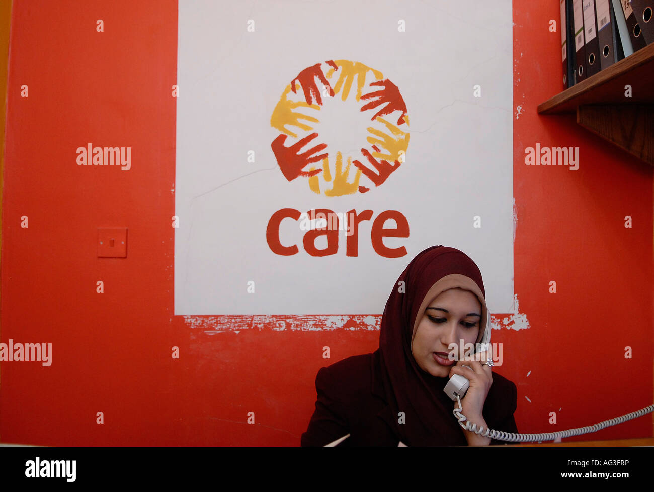 Ein jordanischer Mitarbeiter, der einen Hijab im Büro der INTERNATIONALEN humanitären Hilfsorganisation CARE trägt, die in Amman, Jordanien, Nothilfe leistet Stockfoto