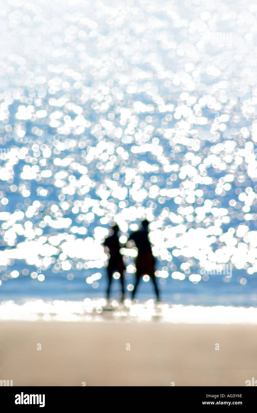 Paar am Strand Silhouette gegen Meer Reflexionen verschwommene soft-Fokus halten einander Stockfoto