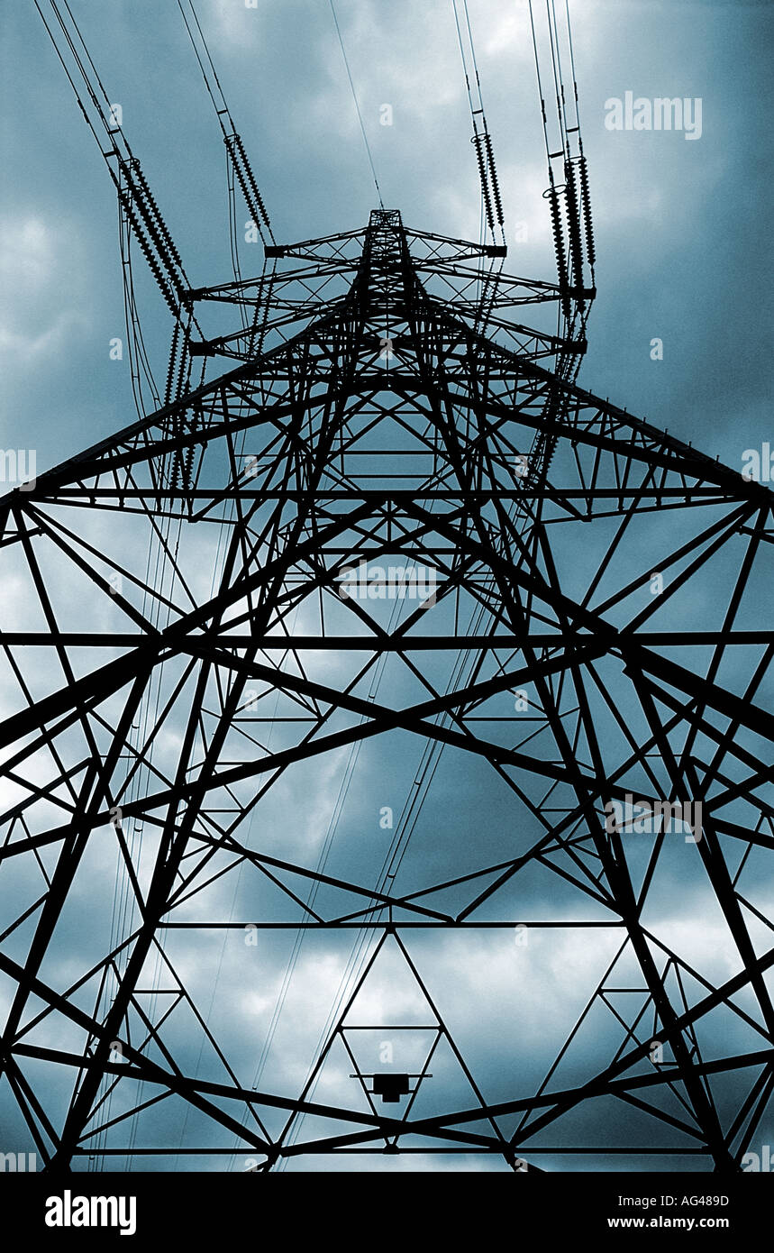 Strom Pylon Silhouette gegen einen stürmischen Himmel, der nach oben blickt. Niedriger Blickpunkt. Stockfoto
