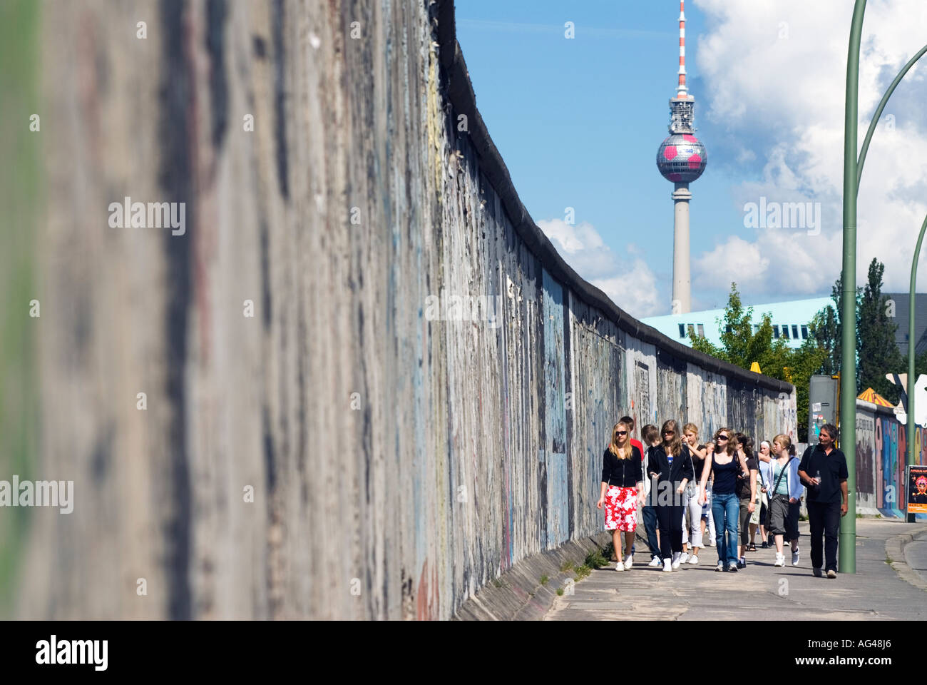 Besucher zur East Side Gallery geht neben Resten der Berliner Mauer in Berlin Stockfoto